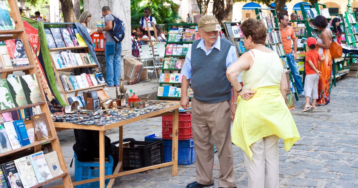un uomo e una donna dinanzi a una bancarella per acquistare libri