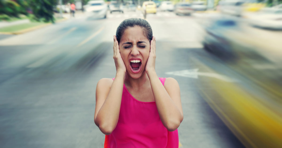 Donna si copre le orecchie per sfuggire alla musica di sottofondo invasiva