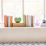 Libri organizzati sul davanzale di una finestra in una casa piccola con luce naturale - Dove mettere i libri in una casa piccola