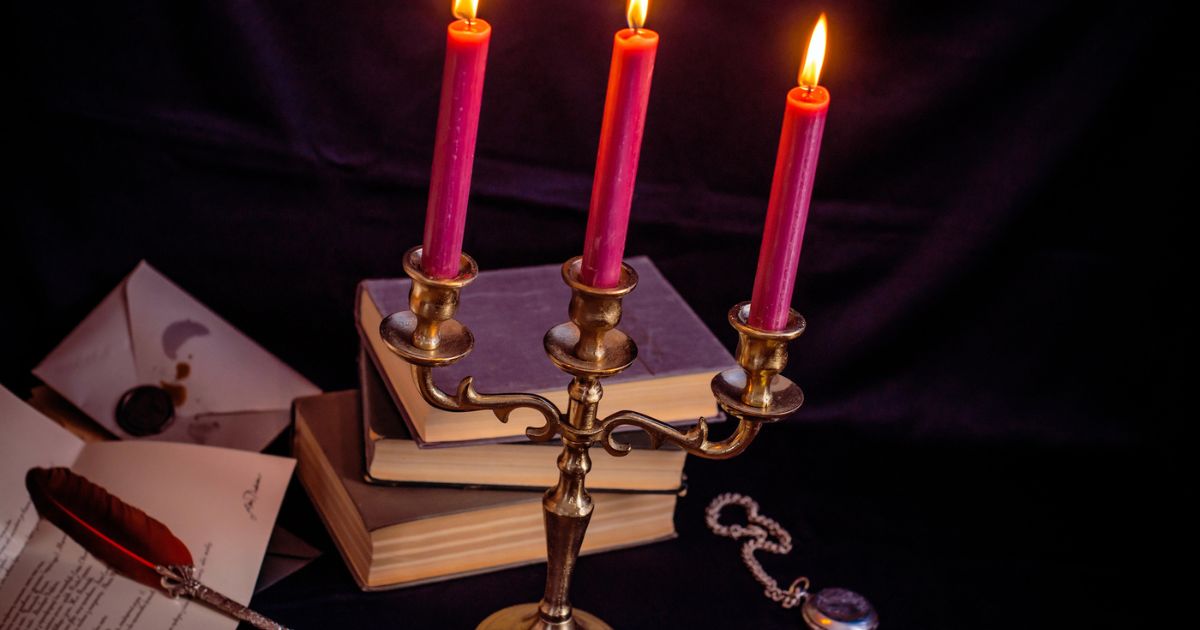 Libri antichi e candele accese che evocano i colpi di scena della letteratura inglese.