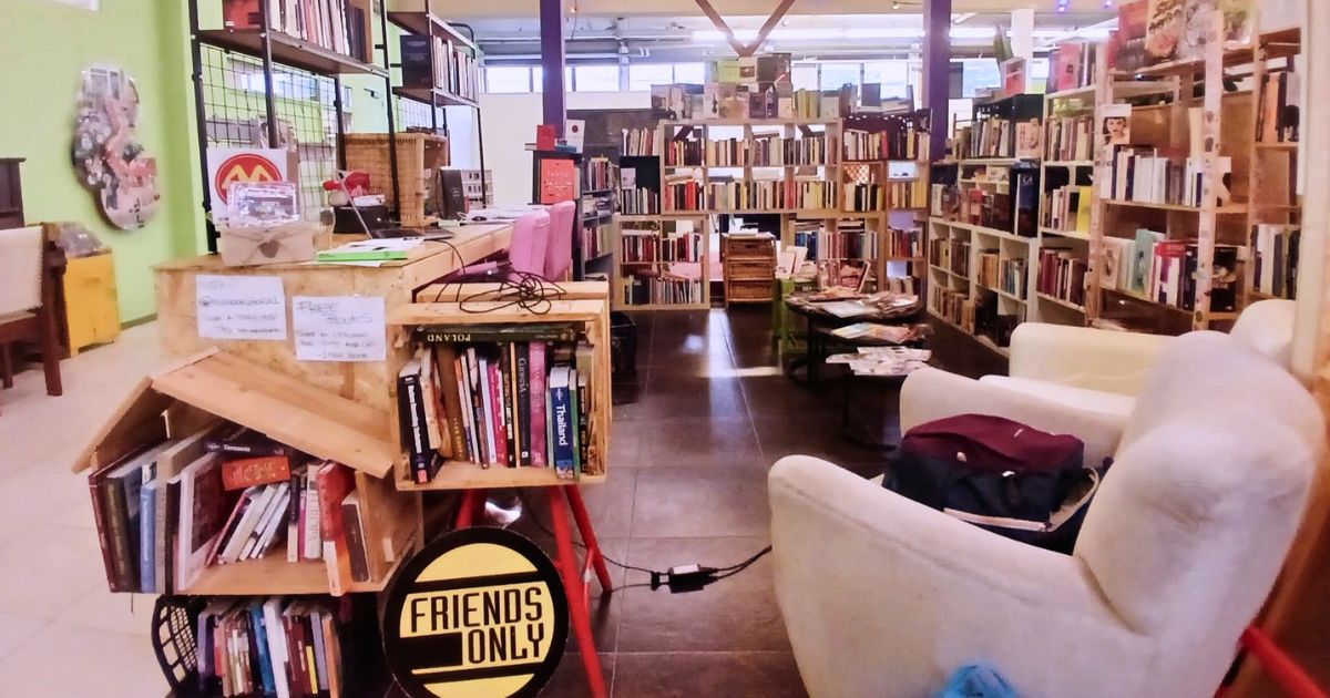 New World Bordel, la biblioteca multilingue di Amsterdam: scaffali con libri in undici lingue, poltrone e il cartello "Friends Only"