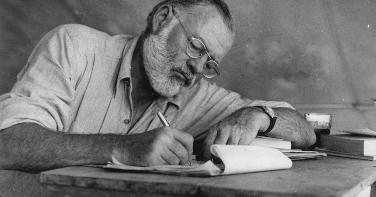 Ernest Hemingway scrive a mano al tavolo in Kenya, a dimostrazione che non è vero che "scrivi da ubriaco e correggi da sobrio"